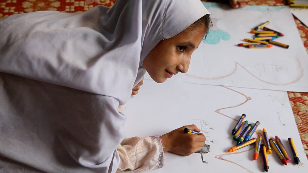 Girl in refugee camp drawing during Storytelling workshop