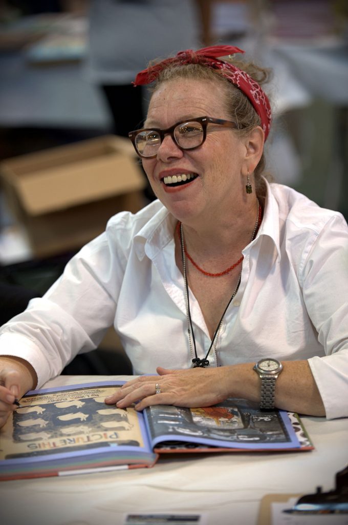 Lynda Barry a famous author smiling while reading a book
