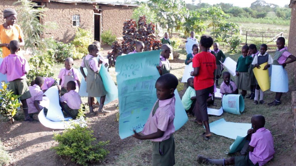Children at AIDS orphanage in Kenya drawing after storytelling session