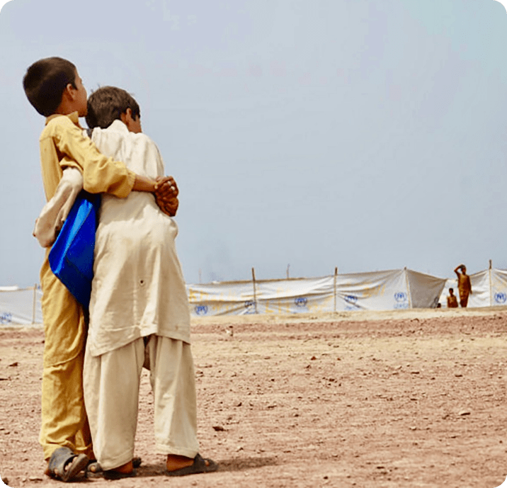 boys embracing in refugee camp