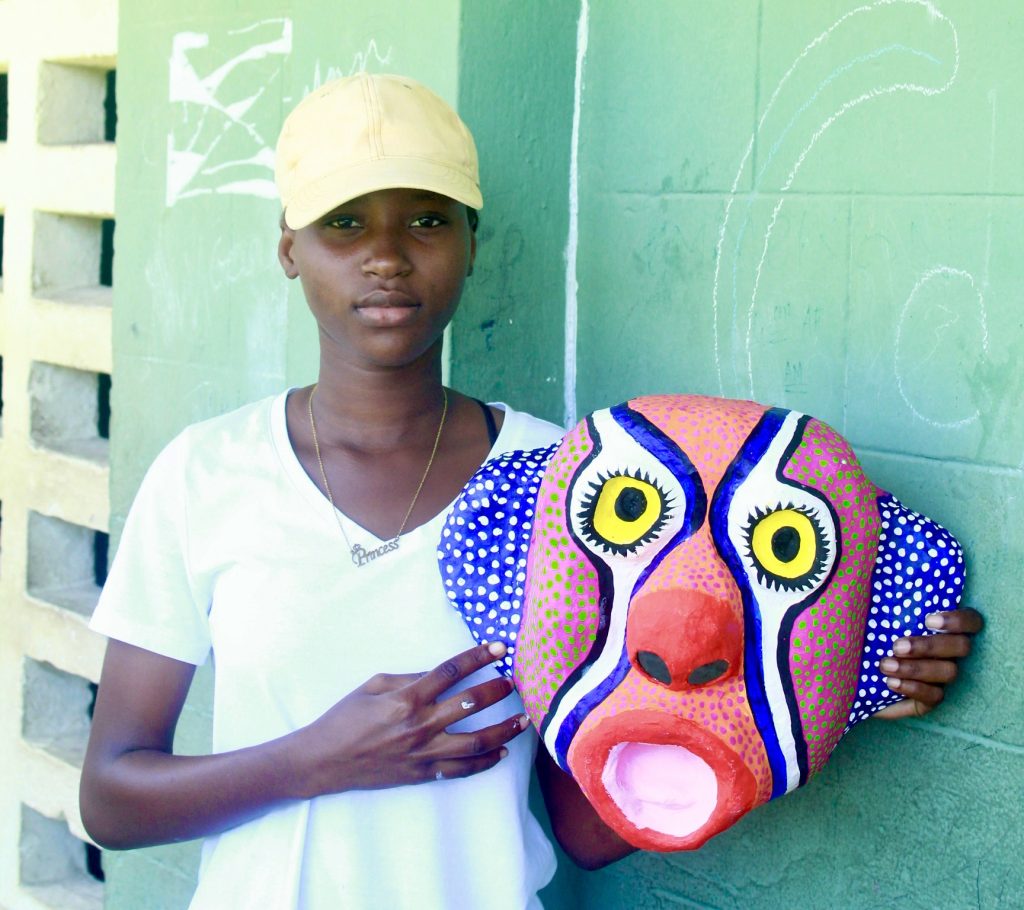 Girl in Haiti attending a CPI mask making workshop.