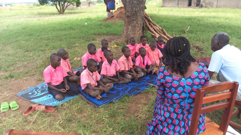 Children, teachers and storyteller in Uganda.