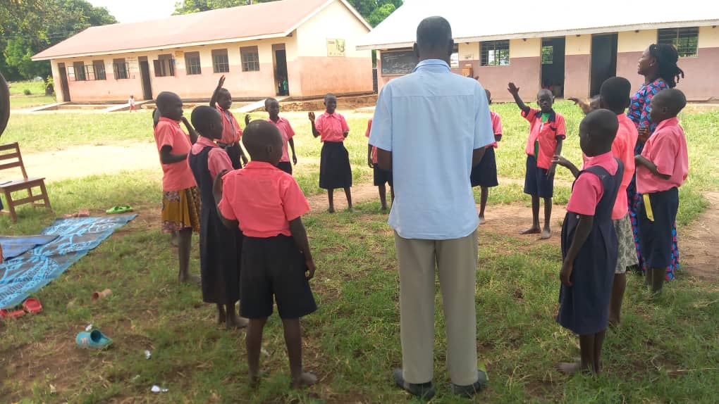 Storyteller and children standing in a circle, Uganda