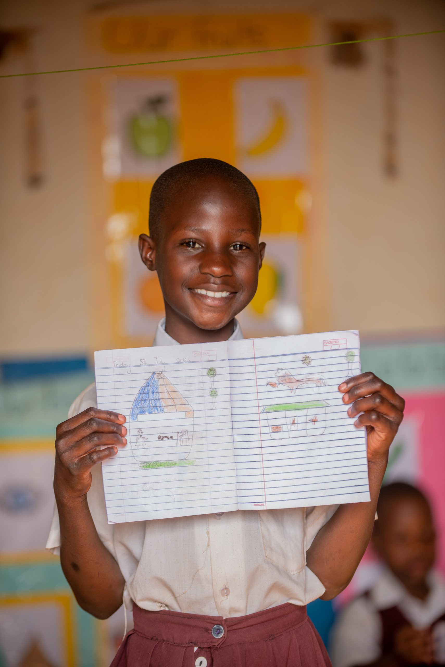 Boy in Kampala, Uganda, showing off his beautiful drawing durin a Youth Sports Uganda and Childsplay International storytelling session.